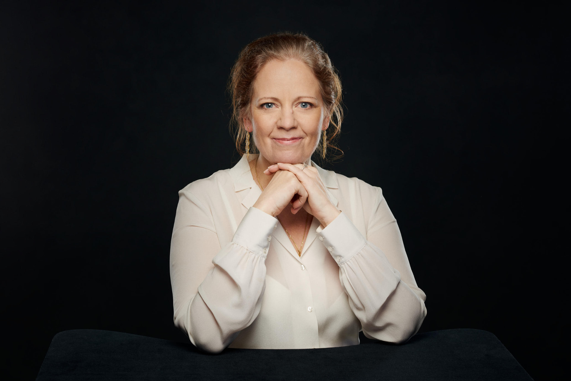 Mae Leyrer, executive confidant, seated at a table